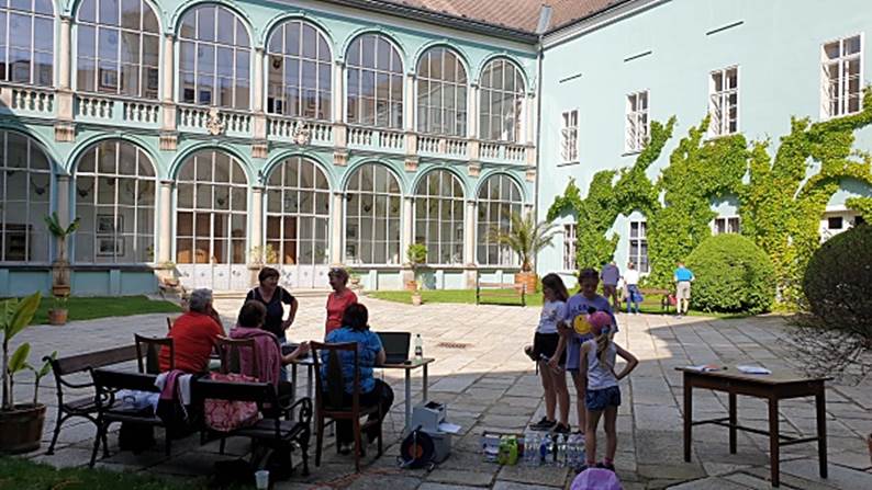 Obsah obrázku venku, budova, nábytek, osoba
Popis byl vytvořen automaticky